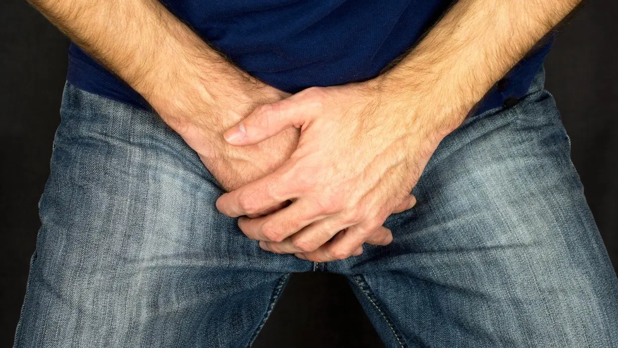 Man cover capping his hands in his lap to cover up erectile dysfunction