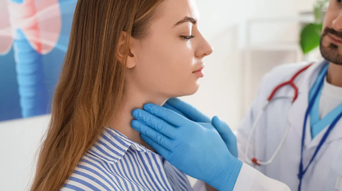 Doctor checking a females thyroid conditions